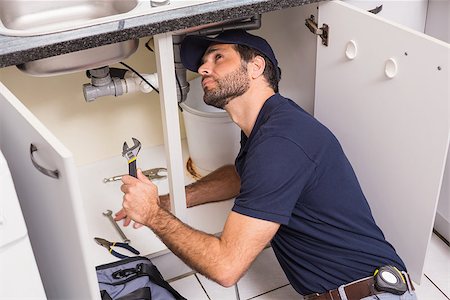 simsearch:6113-06753306,k - Plumber fixing under the sink in the kitchen Stock Photo - Budget Royalty-Free & Subscription, Code: 400-07929410