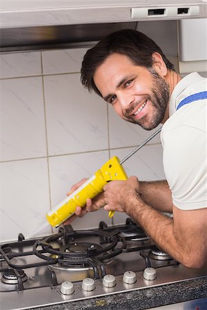 filling (putting) - Plumber putting filling in between tiles in the kitchen Photographie de stock - Aubaine LD & Abonnement, Code: 400-07929445