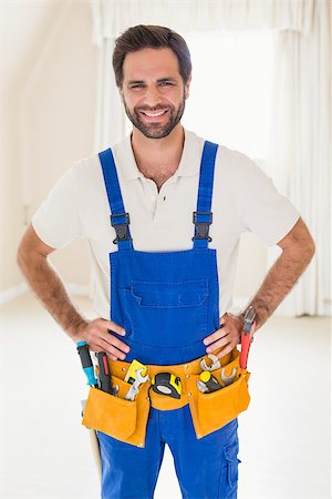 simsearch:400-07929840,k - Handyman smiling at camera in tool belt in a new house Photographie de stock - Aubaine LD & Abonnement, Code: 400-07929477