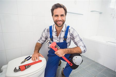 simsearch:400-07929795,k - Plumber smiling at the camera in the bathroom Stock Photo - Budget Royalty-Free & Subscription, Code: 400-07929482