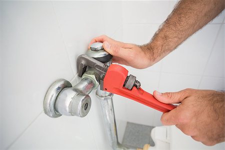 simsearch:400-07929795,k - Plumber fixing tap with wrench in the bathroom Stock Photo - Budget Royalty-Free & Subscription, Code: 400-07929499