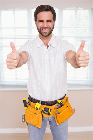simsearch:400-07929840,k - Handyman smiling at camera in tool belt in a new house Photographie de stock - Aubaine LD & Abonnement, Code: 400-07929554