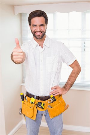 simsearch:400-07929840,k - Handyman smiling at camera in tool belt in a new house Photographie de stock - Aubaine LD & Abonnement, Code: 400-07929556