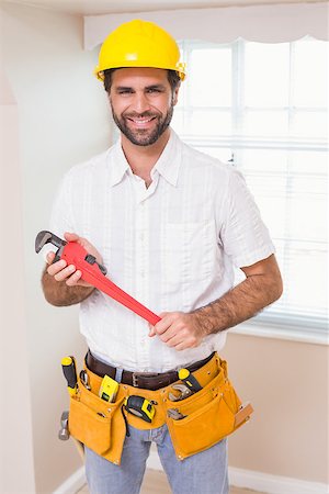 simsearch:400-07929840,k - Handyman smiling at camera in tool belt in a new house Photographie de stock - Aubaine LD & Abonnement, Code: 400-07929557
