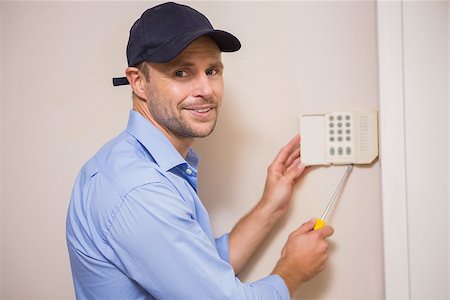 sécurité de la maison - Handyman fixing an alarm system on the wall Photographie de stock - Aubaine LD & Abonnement, Code: 400-07929675