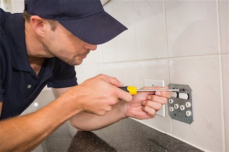 Electrician unscrewing face plate of plug socket in the kitchen Stock Photo - Budget Royalty-Free & Subscription, Code: 400-07929697