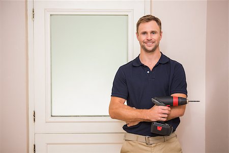 simsearch:400-07929840,k - Construction worker holding power tool with arms crossed in a new house Photographie de stock - Aubaine LD & Abonnement, Code: 400-07929714