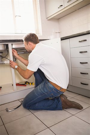 simsearch:400-07929361,k - Plumber fixing under the sink in the kitchen Stockbilder - Microstock & Abonnement, Bildnummer: 400-07929798