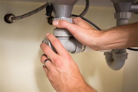 simsearch:400-07929361,k - Plumber fixing under the sink in the kitchen Stockbilder - Microstock & Abonnement, Bildnummer: 400-07929809