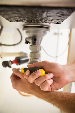 simsearch:400-07929795,k - Plumber fixing under the sink in the kitchen Stock Photo - Budget Royalty-Free & Subscription, Code: 400-07929810