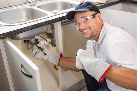 simsearch:400-07929795,k - Plumber fixing under the sink in the kitchen Stock Photo - Budget Royalty-Free & Subscription, Code: 400-07929813