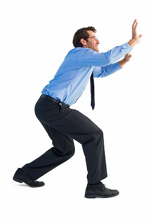 simsearch:400-07665425,k - Businessman standing with bent legs and pushing on white background Stockbilder - Microstock & Abonnement, Bildnummer: 400-07929970