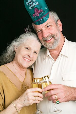 Beautiful senior couple toasting in the New Year with champagne.  Black background. Stock Photo - Budget Royalty-Free & Subscription, Code: 400-07920880