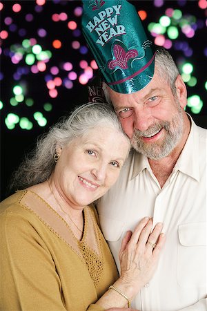 Beautiful couple in their sixties posing for a romantic portrait on New Year's Eve.  Fireworks in the background. Stock Photo - Budget Royalty-Free & Subscription, Code: 400-07920883