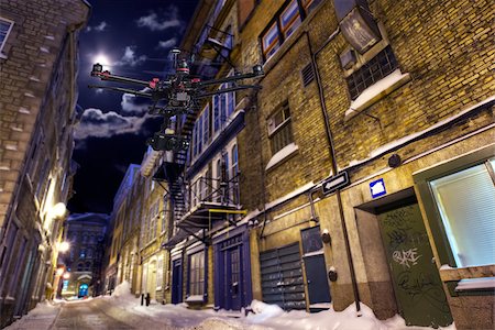 simsearch:695-05777082,k - A drone with a camera is flying along a deserted street in a winter night. Foto de stock - Royalty-Free Super Valor e Assinatura, Número: 400-07920990