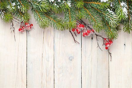 Christmas wooden background with fir tree and holly berry. View from above with copy space Foto de stock - Super Valor sin royalties y Suscripción, Código: 400-07921435