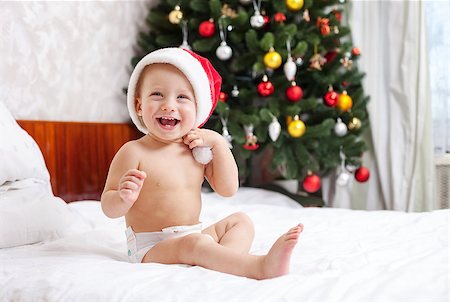 simsearch:400-07088886,k - Christmas baby in santa hat sitting on bed and laughing Stock Photo - Budget Royalty-Free & Subscription, Code: 400-07921808