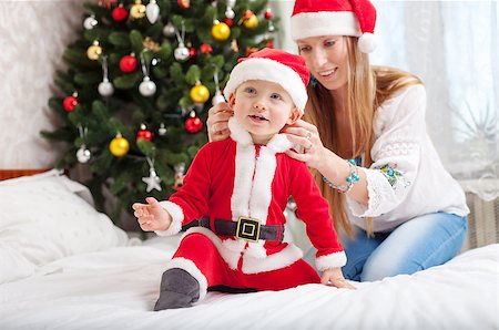 pictures of babies dressed for christmas - Happy mother putting Santa costume on toddler son at home Photographie de stock - Aubaine LD & Abonnement, Code: 400-07921814