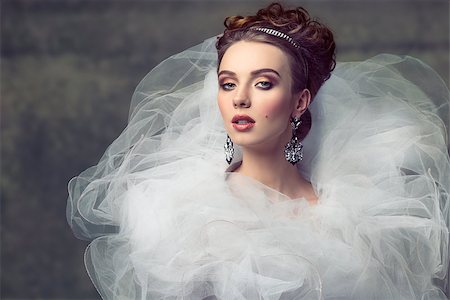 cute young girl wearing like sophisticated dame with creative romantic dress, elegant hair-style, shiny tiara, precious earrings and stylish make-up. Looking in camera with arrogant expression Stock Photo - Budget Royalty-Free & Subscription, Code: 400-07922626