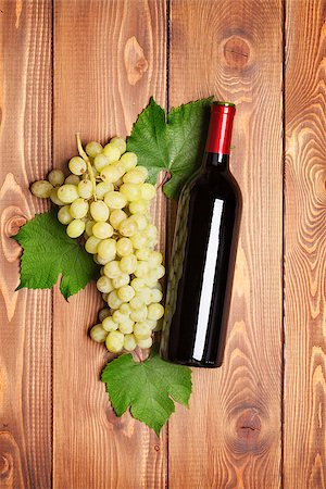 simsearch:400-08110621,k - Red wine bottle and bunch of white grapes on wooden table background Stock Photo - Budget Royalty-Free & Subscription, Code: 400-07922789