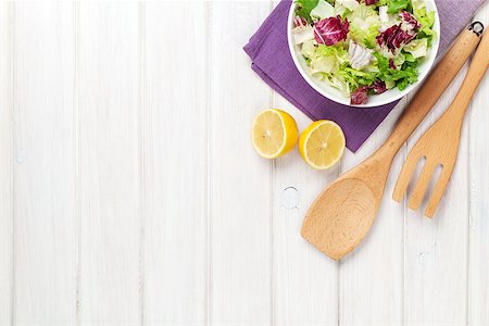 Fresh healthy salad and kitchen utensils over white wooden table. View from above with copy space Stock Photo - Budget Royalty-Free & Subscription, Code: 400-07922887