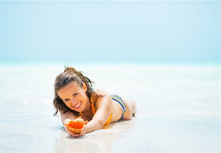 simsearch:400-06207710,k - Young woman with shell laying on sea shore Foto de stock - Super Valor sin royalties y Suscripción, Código: 400-07923285