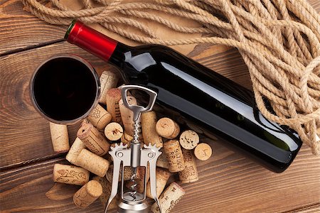 simsearch:400-07937813,k - Red wine bottle, glass, corks and corkscrew. View from above over rustic wooden table background Photographie de stock - Aubaine LD & Abonnement, Code: 400-07934002