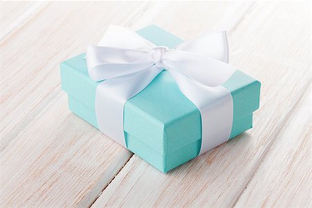 Gift box with bow over white wooden table Stock Photo - Budget Royalty-Free & Subscription, Code: 400-07934033