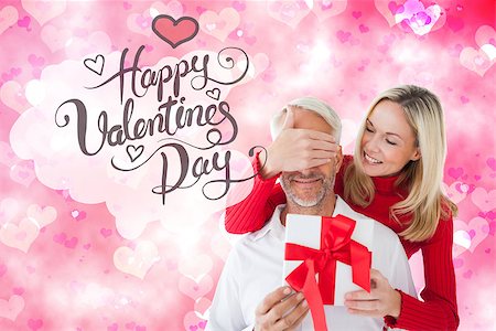 simsearch:400-07957805,k - Loving couple with gift against digitally generated girly heart design Photographie de stock - Aubaine LD & Abonnement, Code: 400-07934505