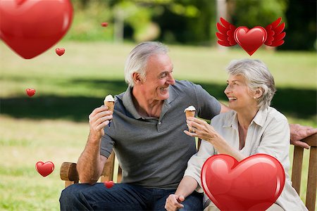 Senior couple eating an ice cream on a bench against hearts Stock Photo - Budget Royalty-Free & Subscription, Code: 400-07934663