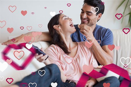 popcorn pattern - Playful couple watching TV while eating popcorn against love heart pattern Stock Photo - Budget Royalty-Free & Subscription, Code: 400-07934689