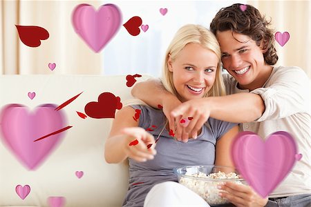 popcorn pattern - Cute couple watching TV while eating popcorn against love heart pattern Stock Photo - Budget Royalty-Free & Subscription, Code: 400-07934698