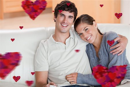 simsearch:400-05748048,k - Happy couple enjoying their time together on the couch against hearts Stockbilder - Microstock & Abonnement, Bildnummer: 400-07934727