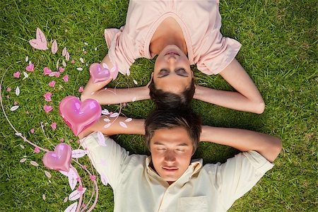 Woman and a man lying head to head with both hands behind their neck against valentines heart design Stock Photo - Budget Royalty-Free & Subscription, Code: 400-07934771