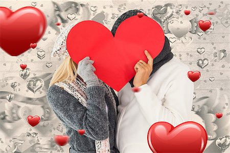 simsearch:400-07957430,k - Couple in winter fashion posing with heart shape against grey valentines heart pattern Photographie de stock - Aubaine LD & Abonnement, Code: 400-07935062