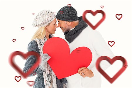 simsearch:400-07957430,k - Smiling couple in winter fashion posing with heart shape against hearts Photographie de stock - Aubaine LD & Abonnement, Code: 400-07935104