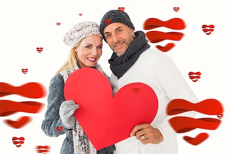 simsearch:400-07957430,k - Smiling couple in winter fashion posing with heart shape against hearts Photographie de stock - Aubaine LD & Abonnement, Code: 400-07935103