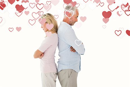 simsearch:400-07726578,k - Unhappy couple not speaking to each other against valentines heart design Fotografie stock - Microstock e Abbonamento, Codice: 400-07935122