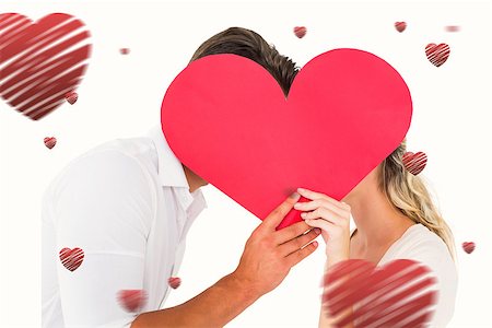 simsearch:400-07935196,k - Attractive young couple kissing behind large heart against hearts Foto de stock - Royalty-Free Super Valor e Assinatura, Número: 400-07935192