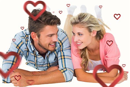 Attractive young couple smiling at each other against hearts Stock Photo - Budget Royalty-Free & Subscription, Code: 400-07935217