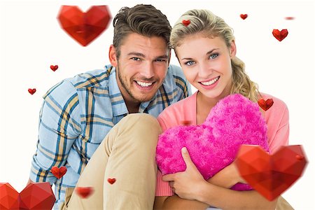 simsearch:400-07935196,k - Attractive young couple sitting holding heart cushion against hearts Foto de stock - Royalty-Free Super Valor e Assinatura, Número: 400-07935223