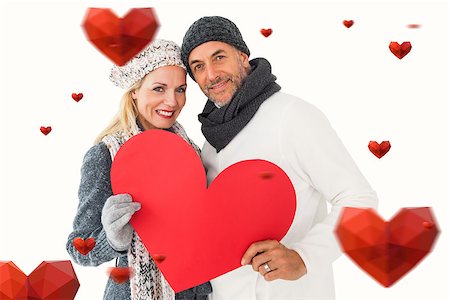 simsearch:400-07957430,k - Smiling couple in winter fashion posing with heart shape against hearts Photographie de stock - Aubaine LD & Abonnement, Code: 400-07935242