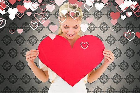simsearch:400-07726694,k - Attractive young blonde showing red heart against grey wallpaper Foto de stock - Royalty-Free Super Valor e Assinatura, Número: 400-07935266