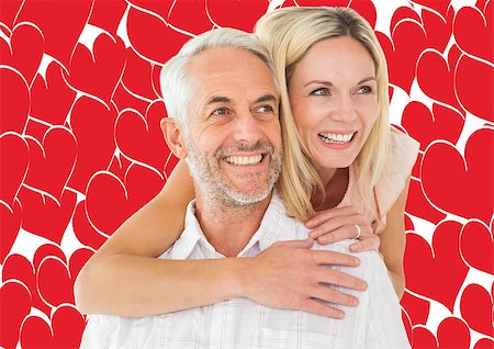 simsearch:400-07957006,k - Happy man giving his partner a piggy back against valentines day pattern Stock Photo - Budget Royalty-Free & Subscription, Code: 400-07935298