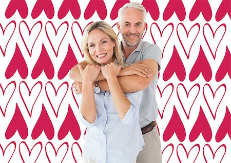 simsearch:400-07957006,k - Happy couple standing and hugging against valentines day pattern Stock Photo - Budget Royalty-Free & Subscription, Code: 400-07935290