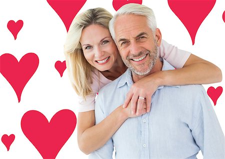 simsearch:400-07957006,k - Smiling couple embracing and looking at camera against valentines day pattern Stock Photo - Budget Royalty-Free & Subscription, Code: 400-07935293