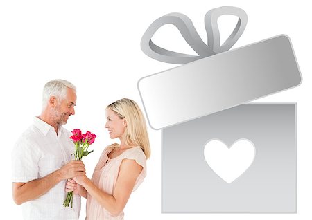 Affectionate man offering his partner roses against gift with heart Stock Photo - Budget Royalty-Free & Subscription, Code: 400-07935332
