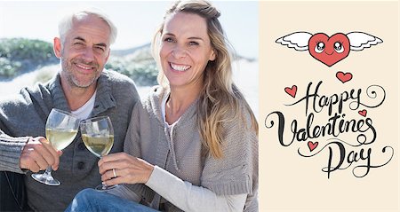 Couple enjoying white wine on picnic at the beach smiling at camera against happy valentines day Stock Photo - Budget Royalty-Free & Subscription, Code: 400-07935607