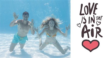 simsearch:400-07583483,k - Cute couple smiling at camera underwater in the swimming pool against love is in the air Foto de stock - Royalty-Free Super Valor e Assinatura, Número: 400-07935643
