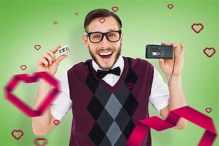 simsearch:400-08380794,k - Geeky hipster holding a retro tape cassette player against green vignette Stockbilder - Microstock & Abonnement, Bildnummer: 400-07935822